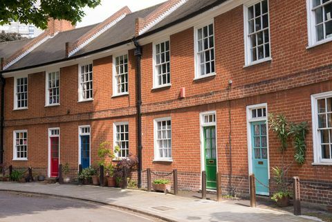 Rumah bata merah Victoria yang dipugar dengan pintu berwarna di jalan lokal di London, Inggris