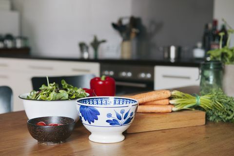 Sayuran dan mangkuk di atas meja kayu di dapur