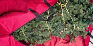 pohon natal buatan besar ditempatkan di tas ritsleting nilon merah