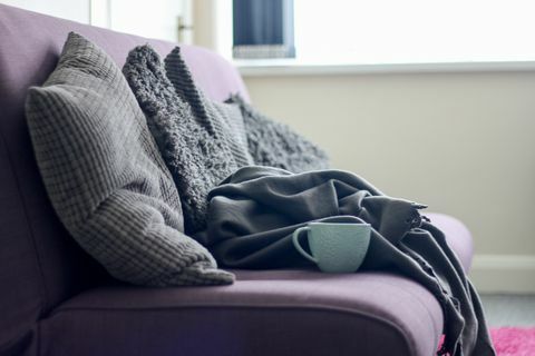 Sofa ungu dengan selimut dan bantal