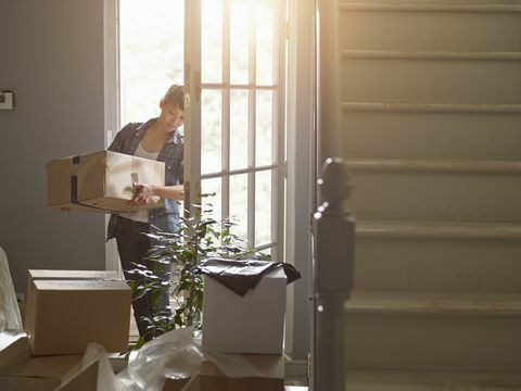 dan wanita membawa kotak kemasan ke rumah barunya