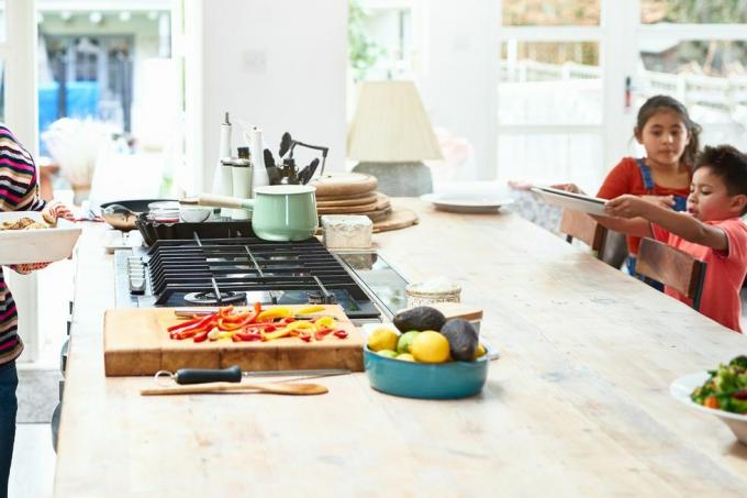 wanita memegang piring casserole panas di dapur