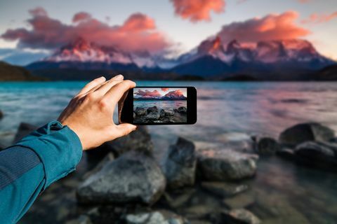 Memotret dengan smartphone di tangan. Konsep perjalanan. Torres del Paine, Chili