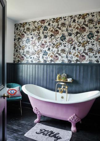 kamar mandi berpanel biru tua dengan bak mandi berdiri bebas merah muda