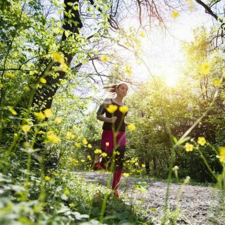 Perempuan berlari kecil melewati hutan