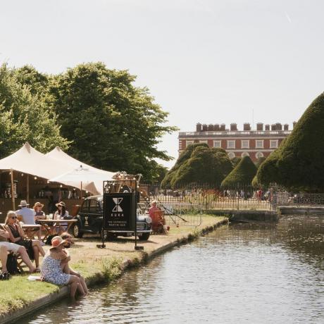 pengunjung bersantai di bar kuka di tepi air panjang di rhs hampton court palace garden festival 2022