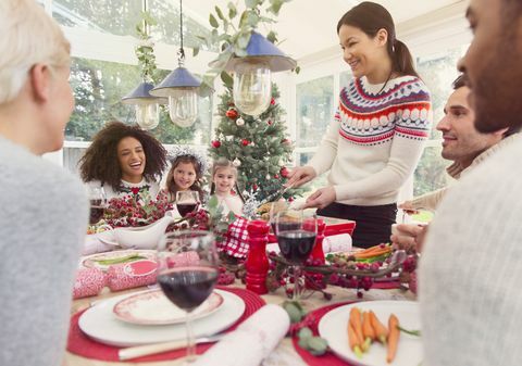 Wanita melayani kalkun di meja makan Natal